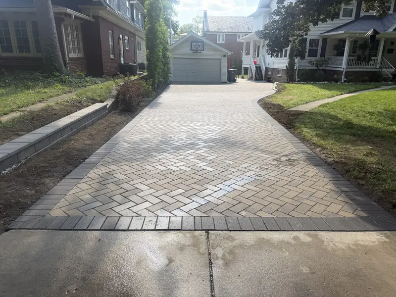 Herringbone paver driveway with a charcoal border leading to a detached garage in Indianapolis