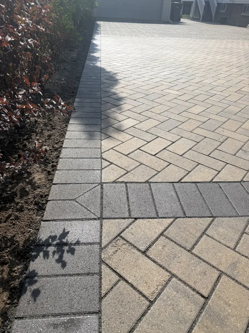 Close view of herringbone pavers and a charcoal soldier-course border in Indianapolis
