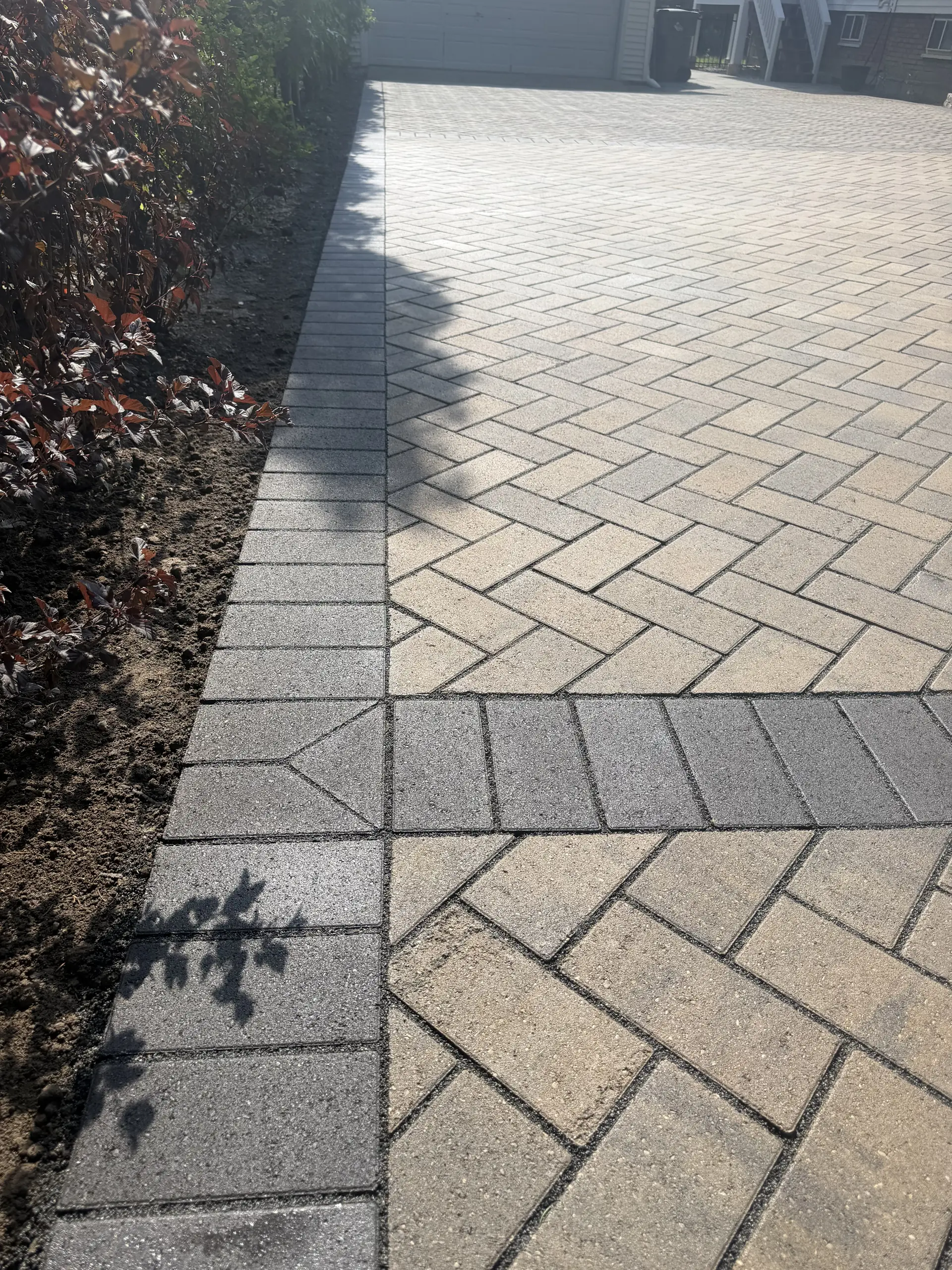 Close view of herringbone pavers and a charcoal soldier-course border in Indianapolis