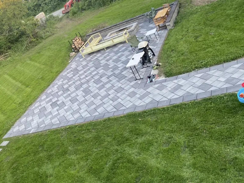 Gray paver patio and walkway set into a sloped lawn in Indianapolis