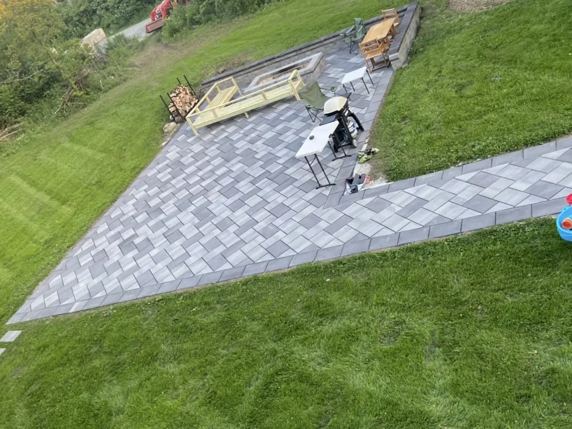 Gray paver patio and walkway set into a sloped lawn in Indianapolis