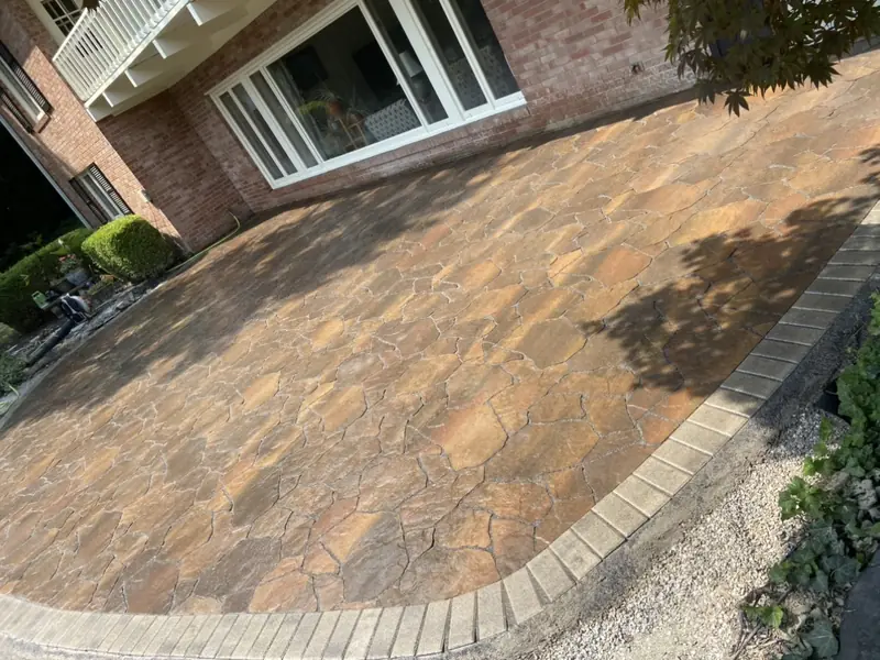 Flagstone-pattern paver patio with a soldier border beside a brick house in Indianapolis