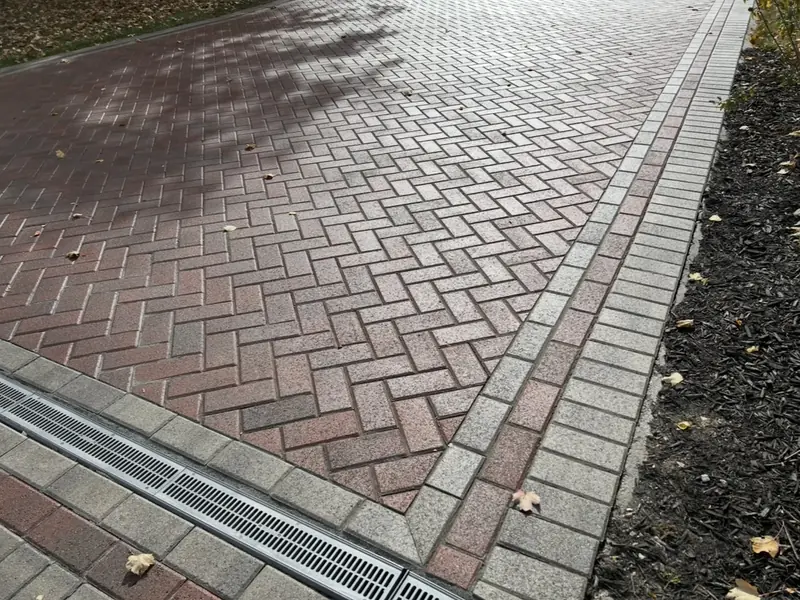 Herringbone pavers with a channel drain set across the surface in Indianapolis