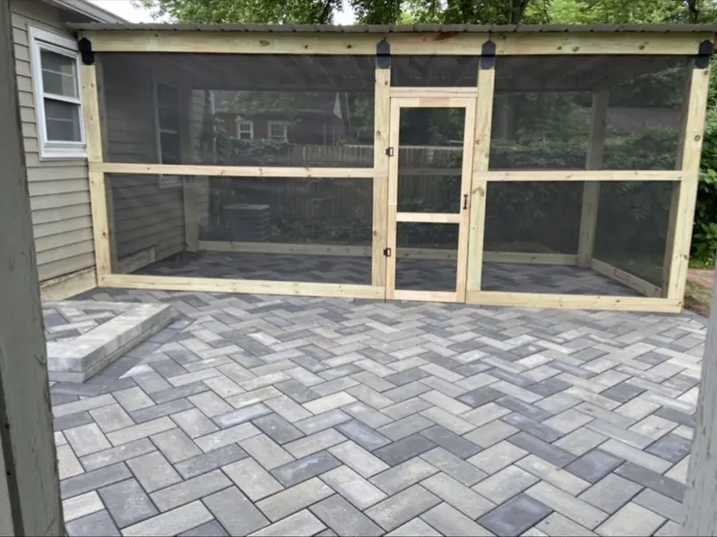Herringbone paver patio in front of a screened outdoor room
