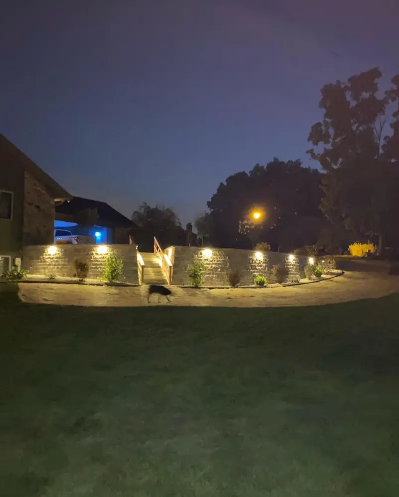Retaining wall with cap lights across a lawn at night in Indianapolis