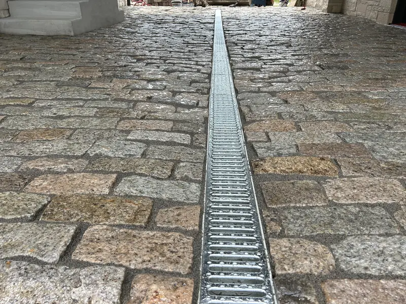 Cobblestone paving with a trench drain down the center in Indianapolis