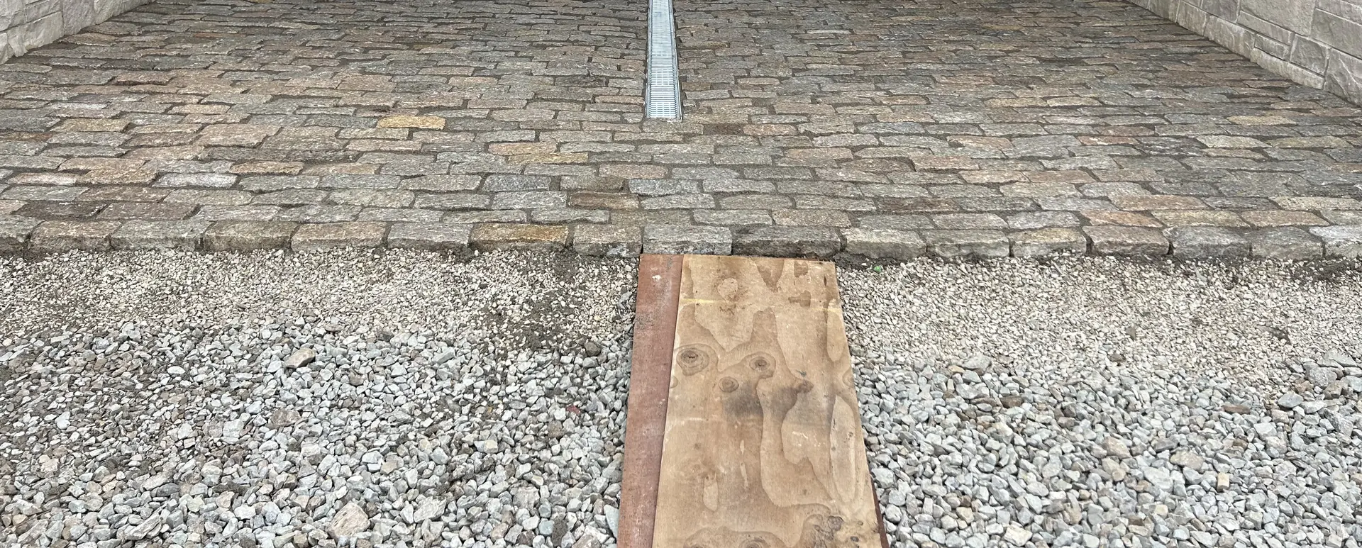 Cobblestone drive with a trench drain under a stone porte-cochère in Bargersville, IN