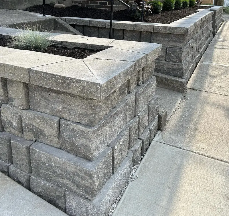 Capped block raised planters with fresh mulch along a sidewalk in Indianapolis